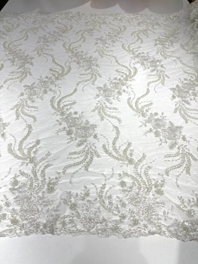 Ivory flowers embroider and heavy beaded on a mesh lace fabric-sold by the yard.