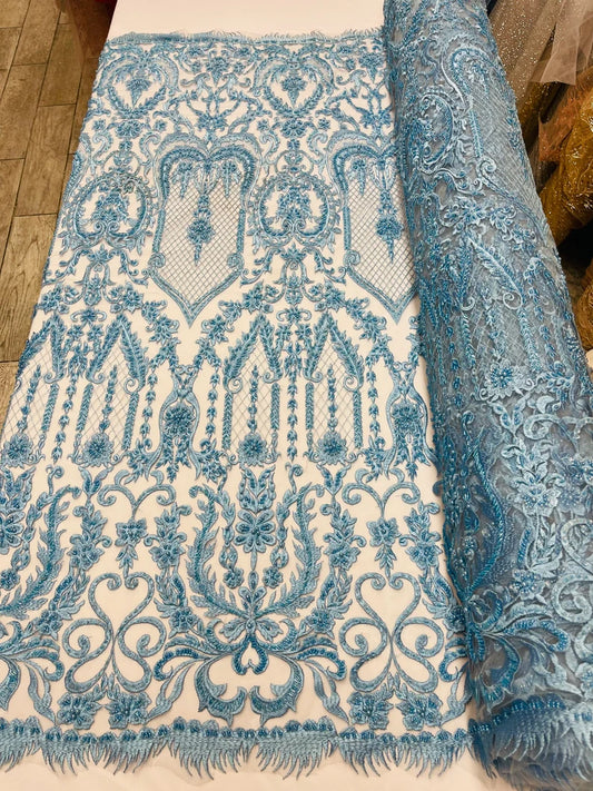 Light blue diva design embroidery with heavy beaded on a mesh lace-sold by the yard.